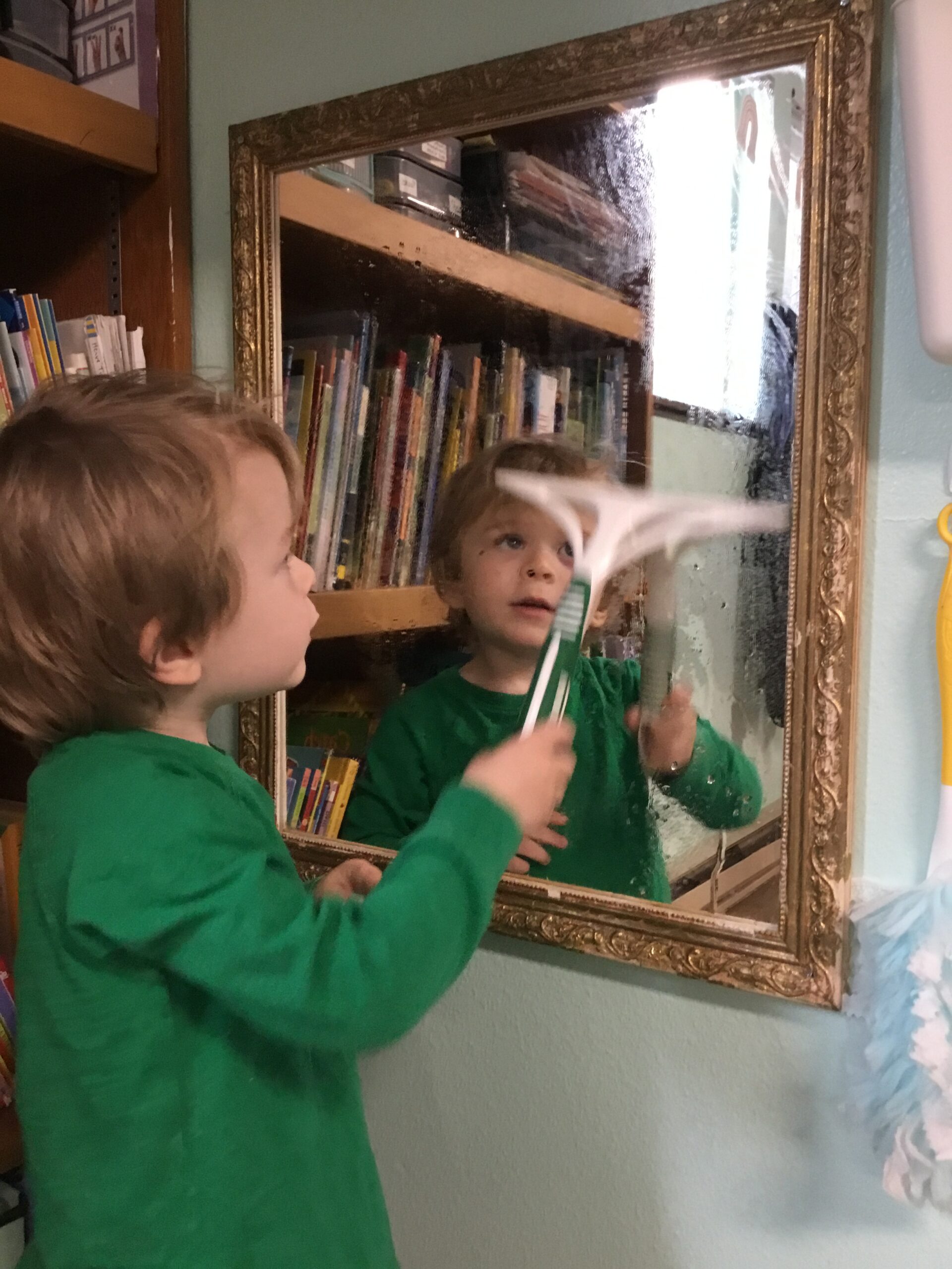 Child using a squeegee on a mirror
