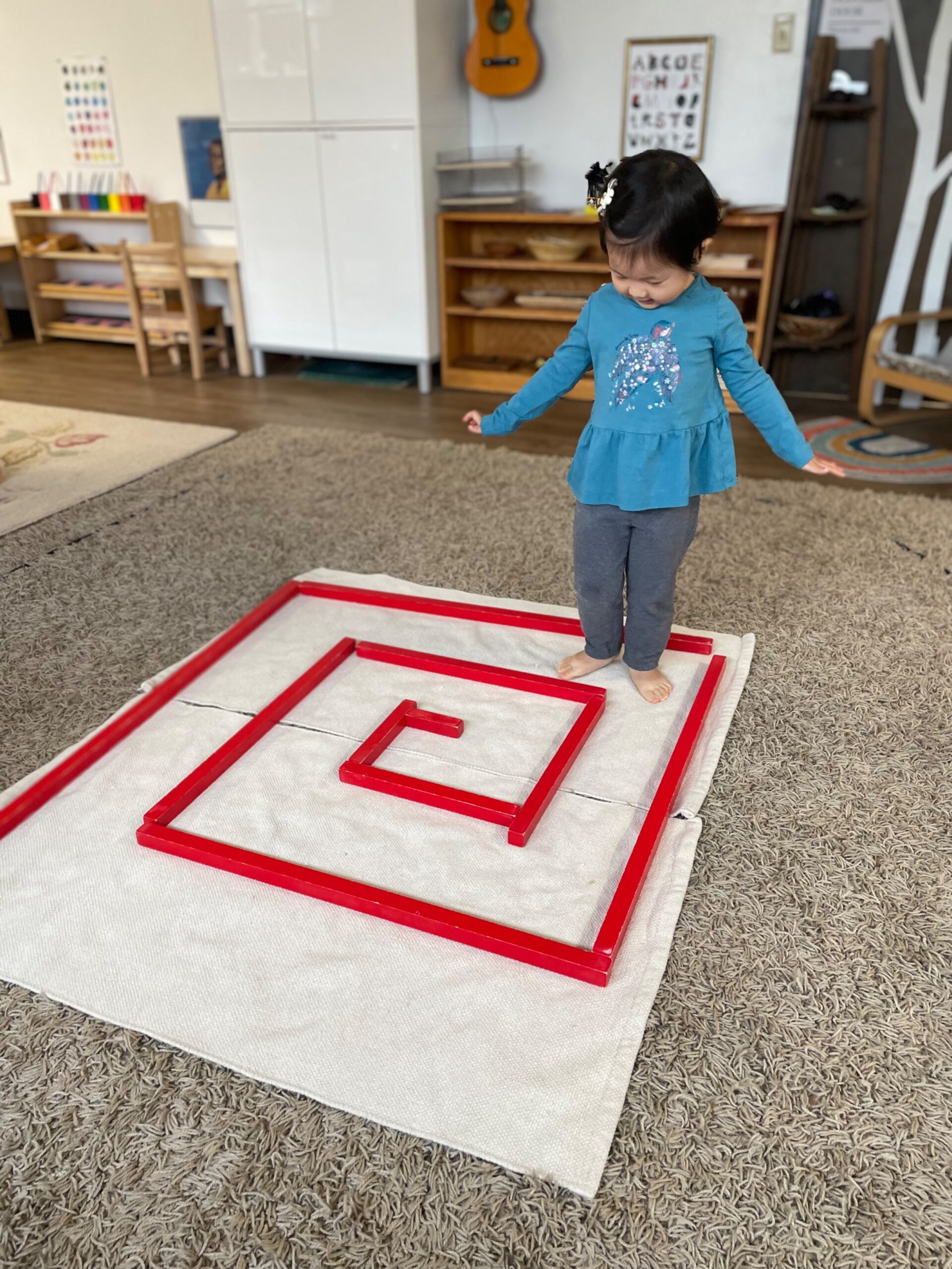 Child balancing before walking through a floor maze.
